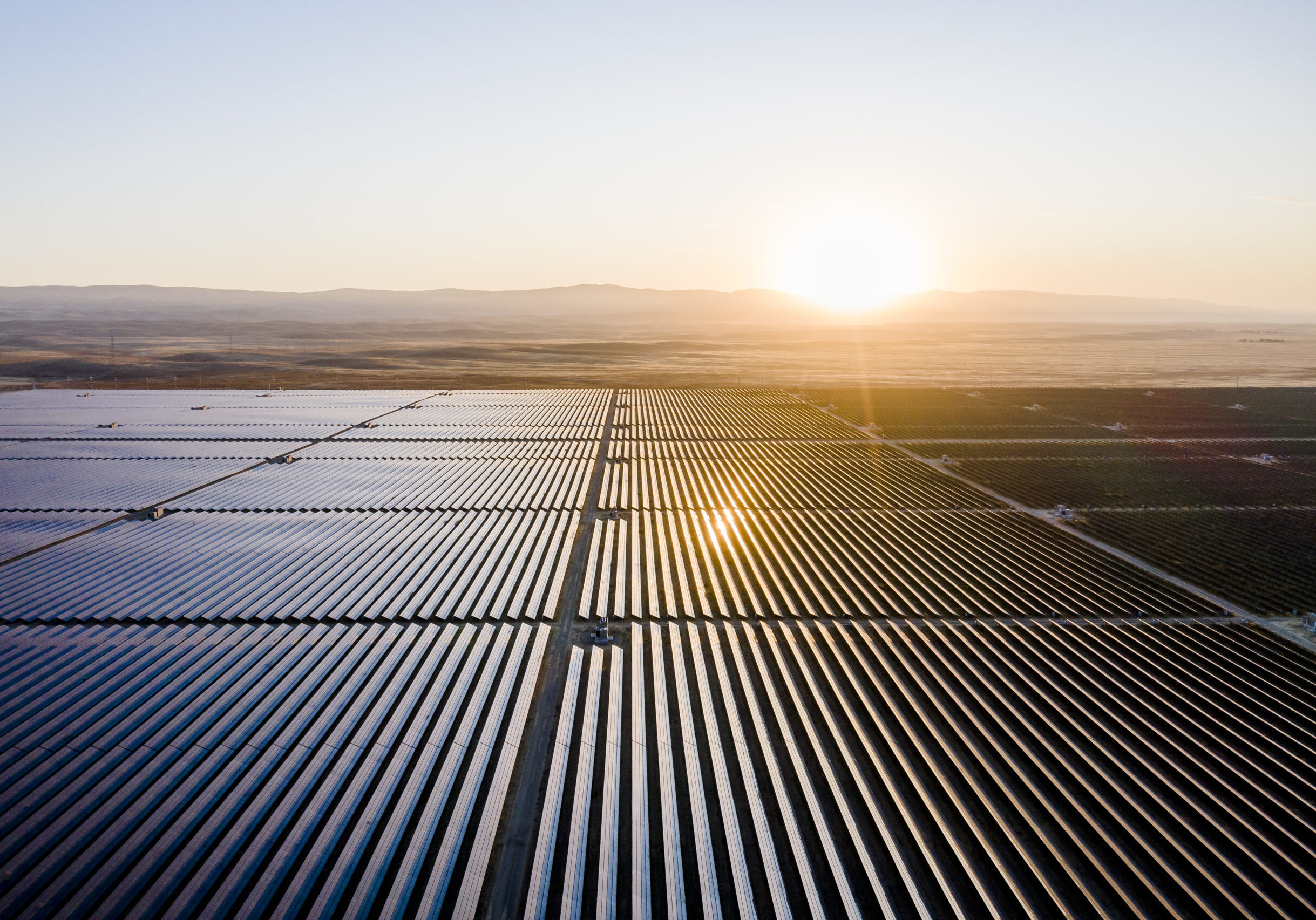Sun rising over solar field, solar panels Aerial view of huge solar farm in the desert