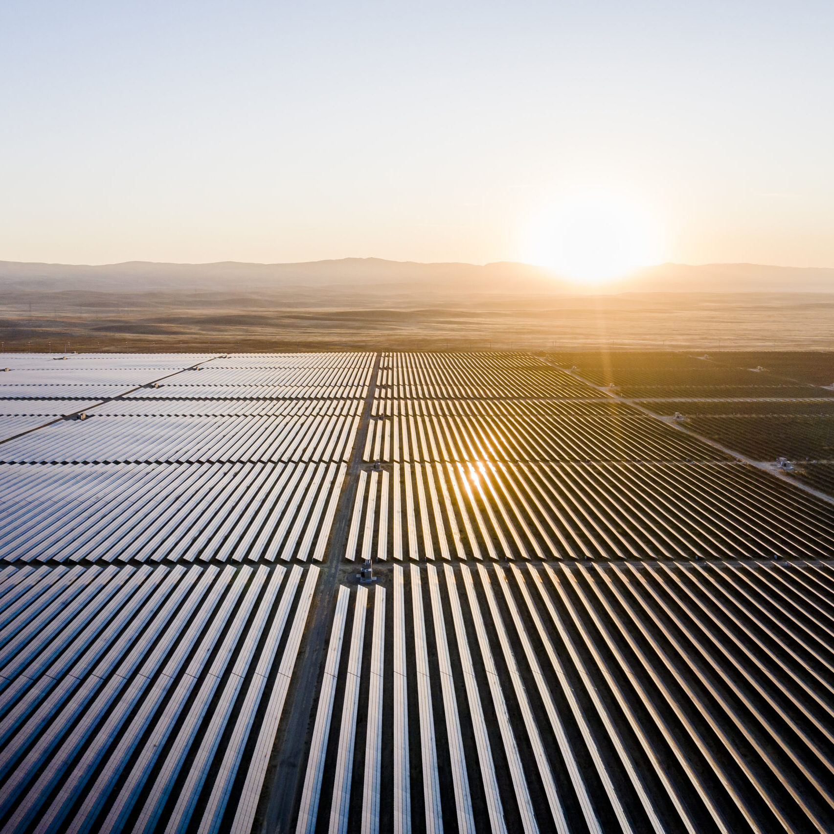 Sun rising over solar field, solar panels Aerial view of huge solar farm in the desert